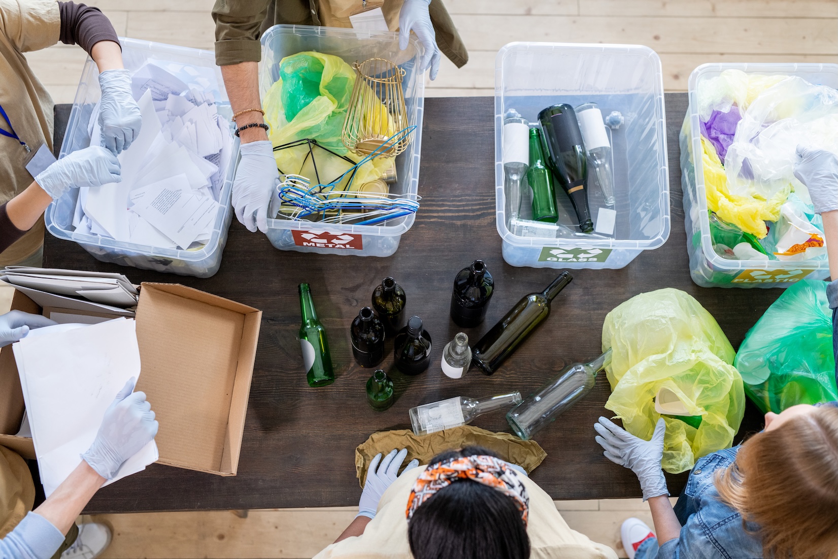 A group of volunteers sitting by table with plastic containers full of trash